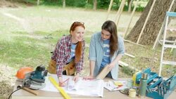 Volunteers reviewing blueprint at construction site Stock Footage