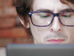 Eyes looking through a pair of glasses at digital tablet Stock Footage