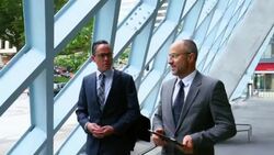 MS TS Two businessmen in discussion while walking outside of office building Stock Footage
