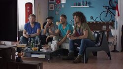 Guys sitting on couch watching tv and cheering Stock Footage