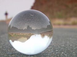 MS CU Crystal ball with inverted man walking on asphalt road/ Tucson, Arizona, United States Stock Footage