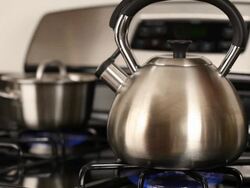 Tea Pot on stove boiling with steam from spout Stock Footage
