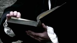 A robed man flips through a book. Stock Footage
