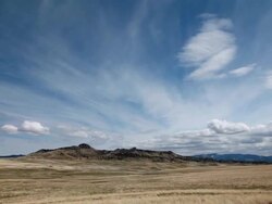 WS T/L View of Dramatic clouds on prairie with Rockie Mountains in back side and sun and shadows rolling across landscape / Augusta, Montana, United States Stock Footage