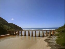 WA Aerial tracking over estuary and bridge to sea, South Africa Stock Footage