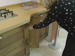 CU T/U mature woman checking build quality of furniture in a kitchen showroom  Stock Footage