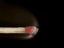 Igniting and burning match against black background, slow motion Stock Footage