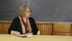 mature teacher reads book with distracted boy Stock Footage