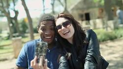 Young couple take selfie with smartphone in public park Stock Footage