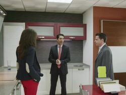 salesman talking to young couple in kitchen furniture showroom Stock Footage