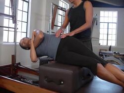 "MS PAN Woman on pilates reformer doing side bends with instructor / Beverly Hills, California, United States" Stock Footage