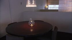 A light fixture shines over a vase on a table in a room with modern decor. Stock Footage