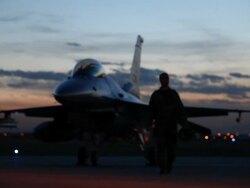 MS F-16 pilot walking away from F-16 fighter jet into light at dusk, Aurora, Colorado, USA Stock Footage