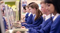 Girl looking at camera while studying in school computer lab Stock Footage