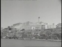 Guards run along a catwalk on Alcatraz as bullets are fired through a window. Stock Footage