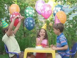 Three child at a birthday party in the garden Stock Footage