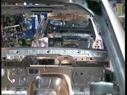 MS Car chassis being lowered onto production line in factory Stock Footage
