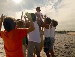Boys jumping and cheering, one boy on man's shoulders Stock Footage