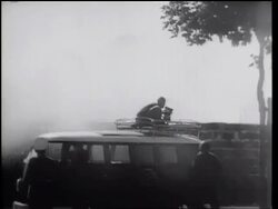 B/W 1961 man with film camera on top of van being sprayed by hose at Berlin Wall / Germany / newsreel Stock Footage