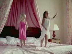 WS, Two girls (2-3, 6-7) jumping on bed, Saint Ferme, Gironde, France Stock Footage