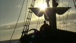 A sailor looks out to sea from the deck of a listing ship. Stock Footage
