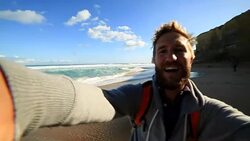 Young man takes a selfie portrait on Gibsons steps beach Stock Footage