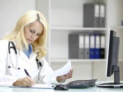 Young woman doctor writing in doctors's office Stock Footage