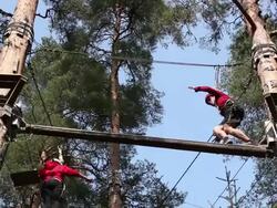 Man balancing on High Ropes course beam Stock Footage