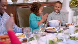 Cute young girl rubs hands together hungrily before serving herself a heaping spoonful of mashed potatoes Stock Footage