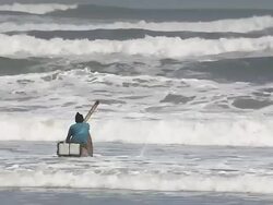 WS TS View of Man paddling traditional reed boat against strong waves / Pimentel, Lambayeque, Peru Stock Footage