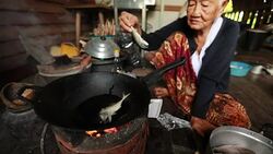 Lifestyle Senior asian woman Sitting a Cooking Food, Slow motion Stock Footage