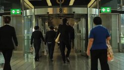 People walk through revolving door at airport Stock Footage