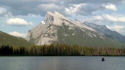 People paddle a rowboat  on a mountain lake in Canada. Stock Footage