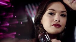 Hollywood starlet with champagne glass leans on man's shoulder and stares at camera at awards show Stock Footage