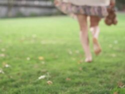 MS SLO MO Shot of young woman in skirt and barefoot, turns and runs away on grass / Portland, Oregon, United States  Stock Footage