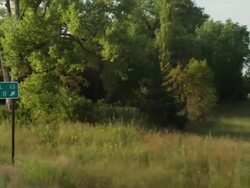 Drive by highway sign O'Neill and Orchard green trees Stock Footage