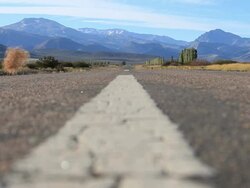 Road and Mountains with tumbleweed in rural Argentina Stock Footage
