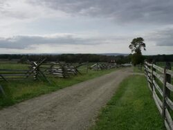 WS View of long dirt road bordered by wooden fence and dark clouds in sky / Gettysburg, Pennsylvania, United States Stock Footage