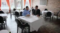Small business owner studies paperwork with financial advisor in restaurant Stock Footage