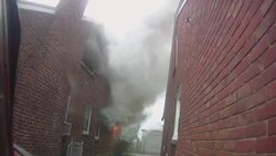 Slow Motion firefighter POV walking around perimeter of burning home Stock Footage