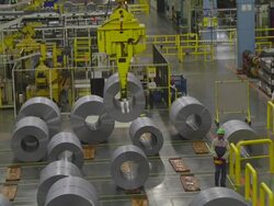 MS PAN TD Worker using remote controlled crane through moving coil of steel in an auto assembly plant warehouse / Princeton, Indiana, United States Stock Footage