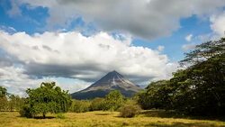 T/L Wide shot of Arenal volcano in clouds Stock Footage