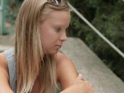 sad woman sitting outdoors alone Stock Footage