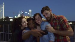 Group of friends pose for selfie and laugh together on Pfluger Bridge with downtown Austin, Texas skyline in background Stock Footage