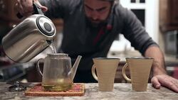 Man pouring hot water into tea jar Stock Footage