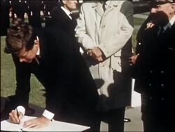 1962 President Kennedy and VP Johnson signing book upon arrival at NATO Atlantic Command Center Stock Footage