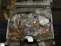 Paper and paper products spill from a dump truck at a paper recycling plant. Stock Footage