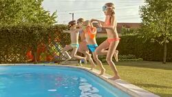 SLO MO TS Four kids jumping into pool together Stock Footage