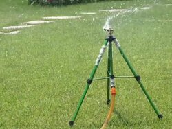 springkler watering park lawn at daytime Stock Footage