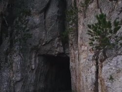 POV driving through forested, rocky area and enter a small rock tunnel. Stock Footage